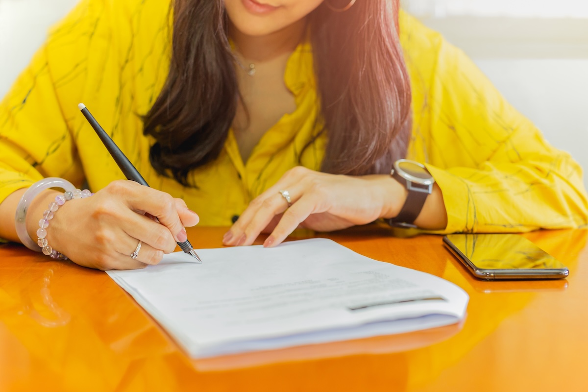 Businesswoman signing contract document paper on wood table | Lika ...